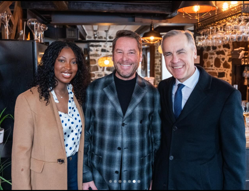 Mark Carney, Tatiana August et Robert Auger posent dans un restaurant aux murs de pierre, éclairé par des suspensions, avec des verres suspendus au bar.