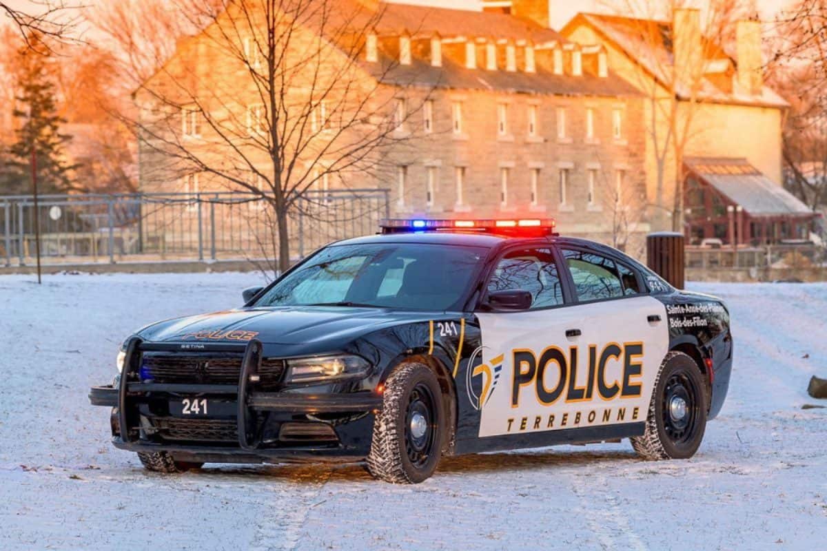Voiture de police Terrebonne stationnée dans la neige avec bâtiment historique en arrière-plan