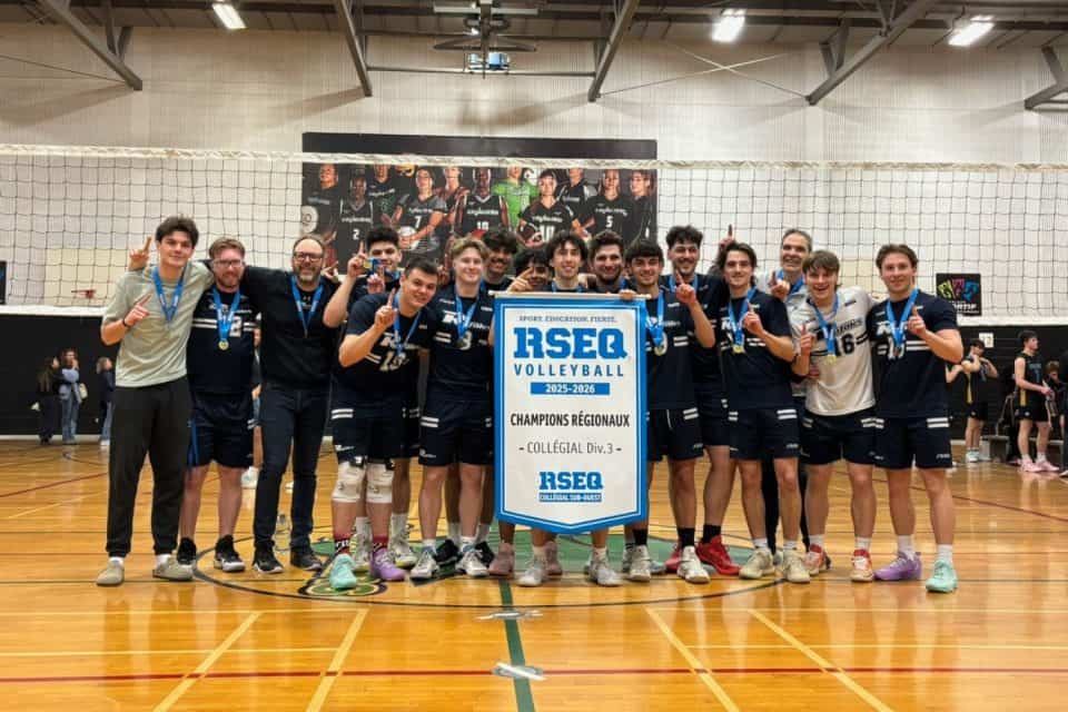 Équipe de volleyball posant avec bannière de championnat régional dans gymnase aux murs blancs