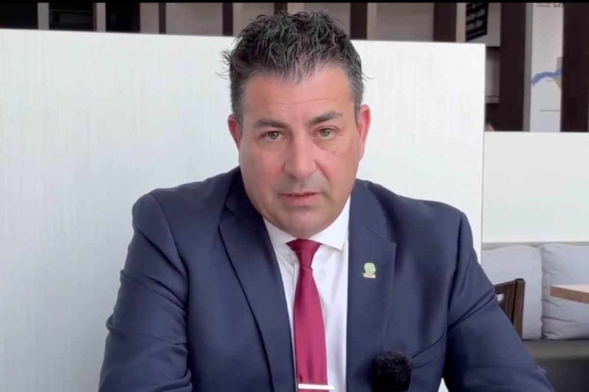 Homme en costume bleu marine parlant lors d'une présentation dans environnement professionnel