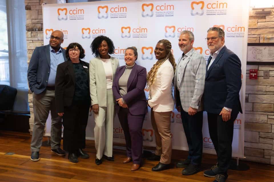Homme en costume parlant au microphone devant cadres dorés et murs verts dans espace d'exposition