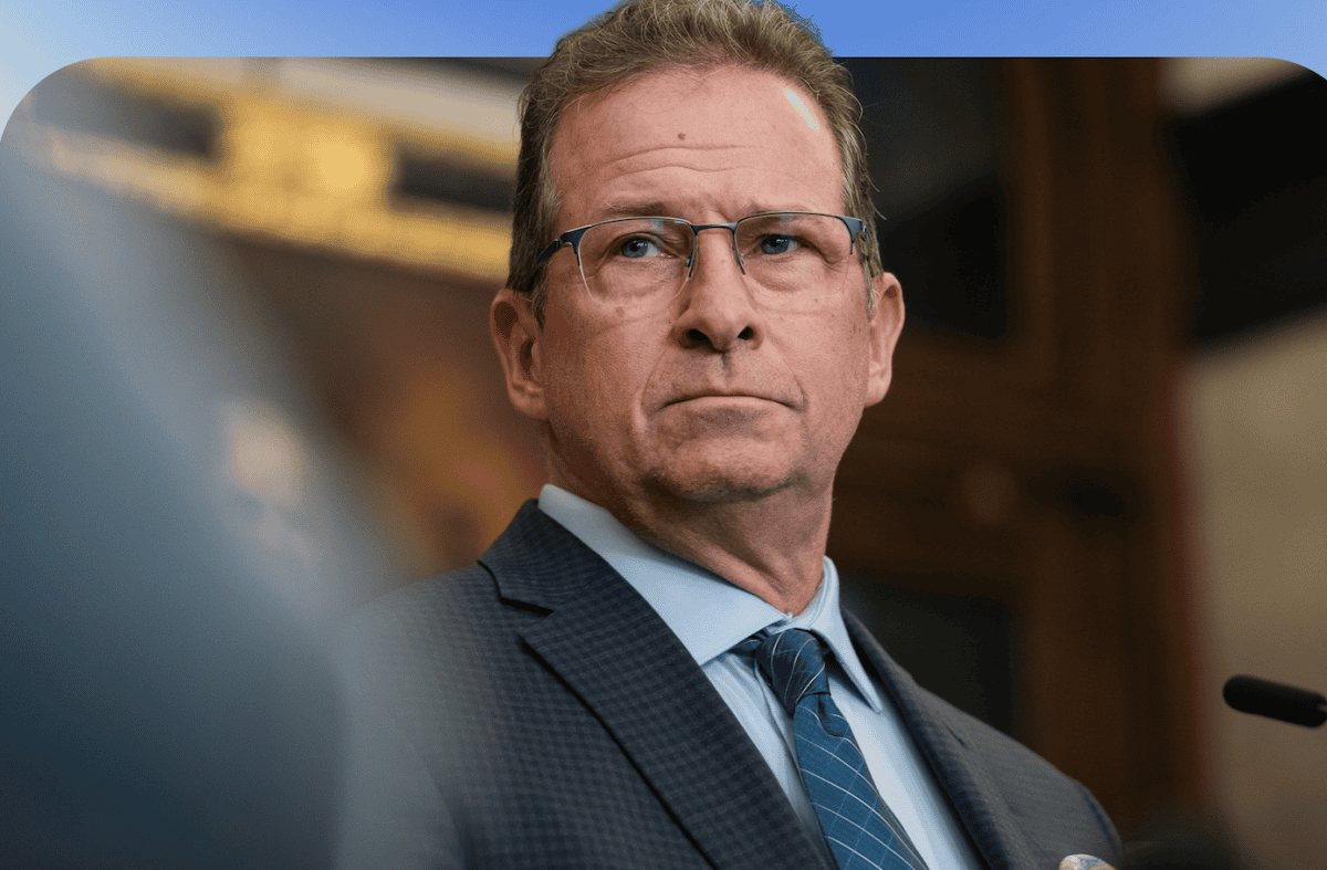 Scène intérieure avec pupitre et micro, dans un environnement institutionnel, éclairage chaud et arrière-plan flou suggérant une salle officielle.