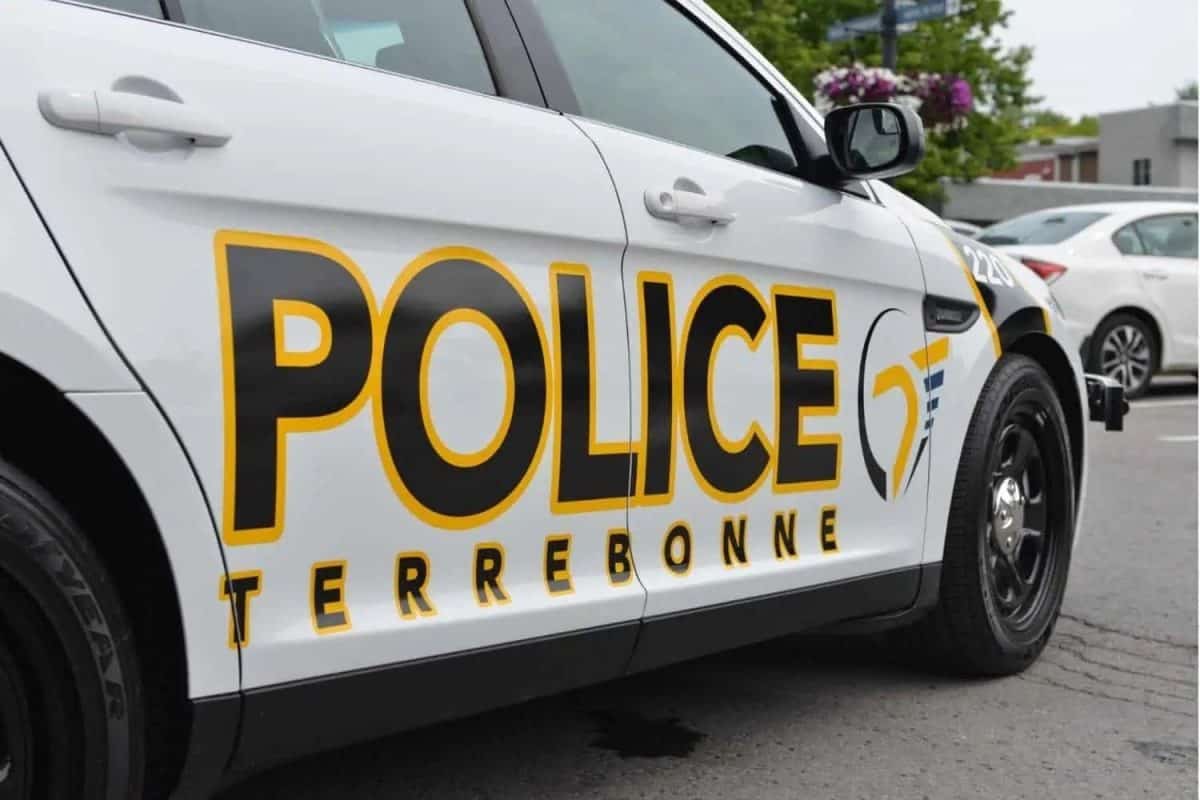 Véhicule de police de Terrebonne en stationnement, logotype noir et jaune visible sur la portière avant