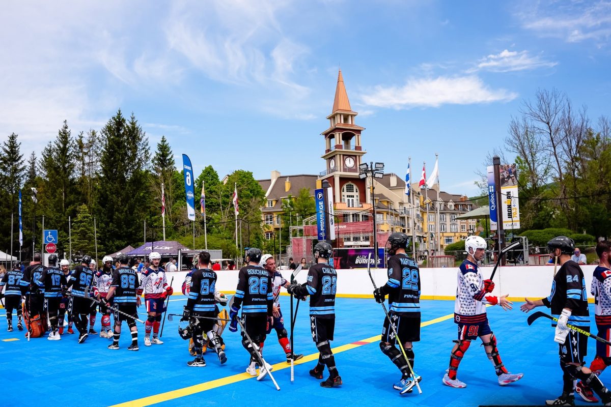 Joueurs de dek hockey se serrant la main sur une patinoire extérieure bleue au pied d'un village de montagne ensoleillé