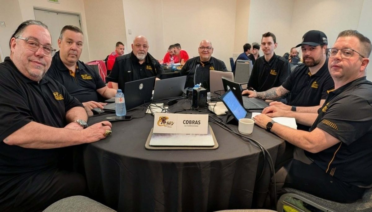 Groupe réuni autour d’une table lors d’une séance de sélection ou de travail. Des ordinateurs portables et des documents sont utilisés dans une salle de conférence, avec une identification des Cobras de Terrebonne au centre.