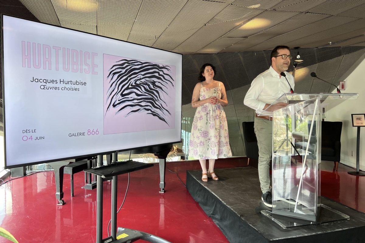 Présentation officielle sur scène devant un écran annonçant l'exposition Hurtubise à la Galerie 866, podium transparent