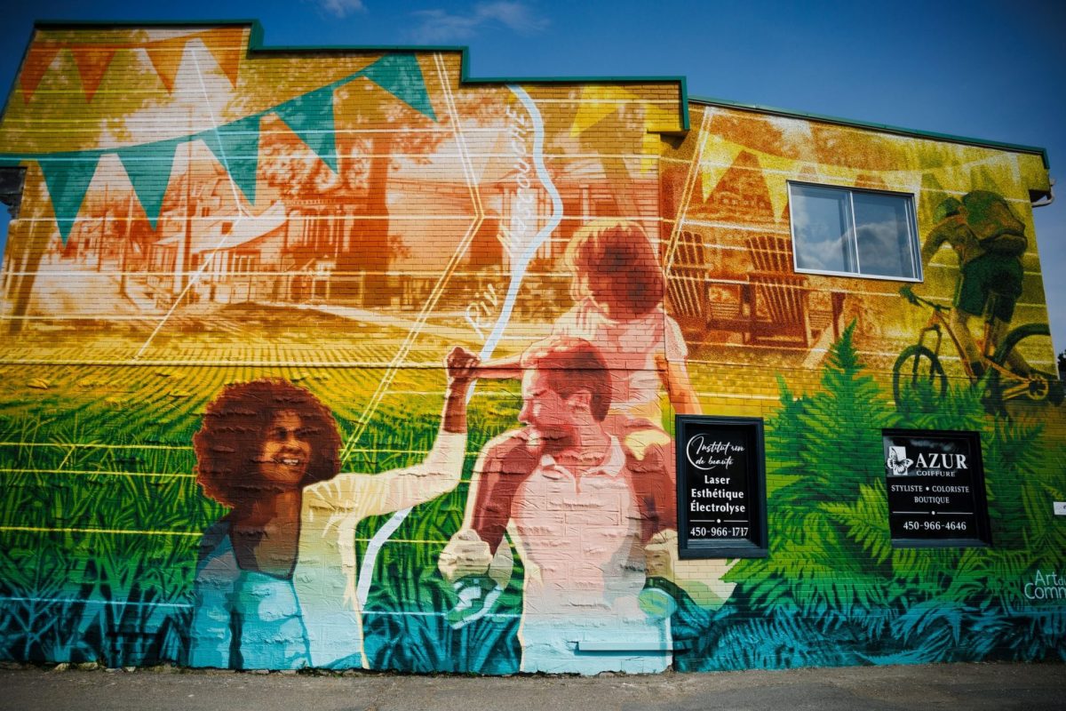 Mur extérieur recouvert d’une fresque colorée illustrant des scènes de vie, des espaces verts et des activités de plein air sous un ciel bleu.