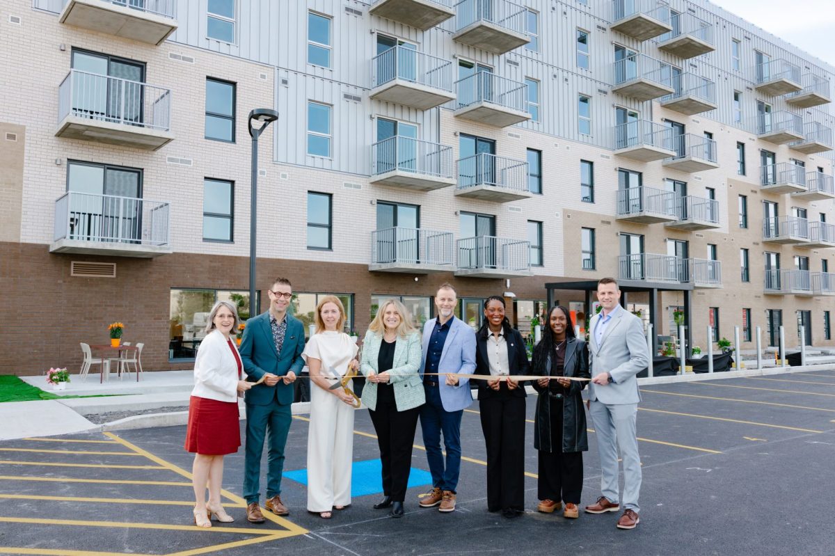 Inauguration d'un immeuble résidentiel moderne, un groupe coupe un ruban doré en cérémonie dans le stationnement