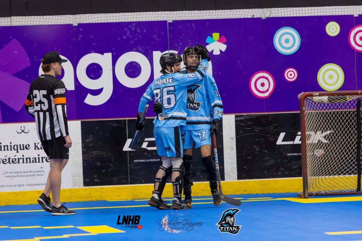 Deux joueurs des Titans de Laval se congratulent près du filet sur un terrain de hockey cosom intérieur