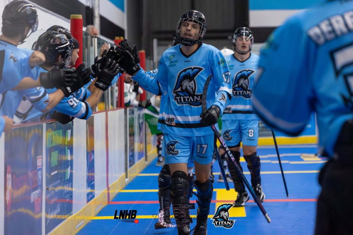 Joueurs des Titans de Laval en hockey ball entrant sur le terrain en se tapant dans les mains le long de la bande vitrée