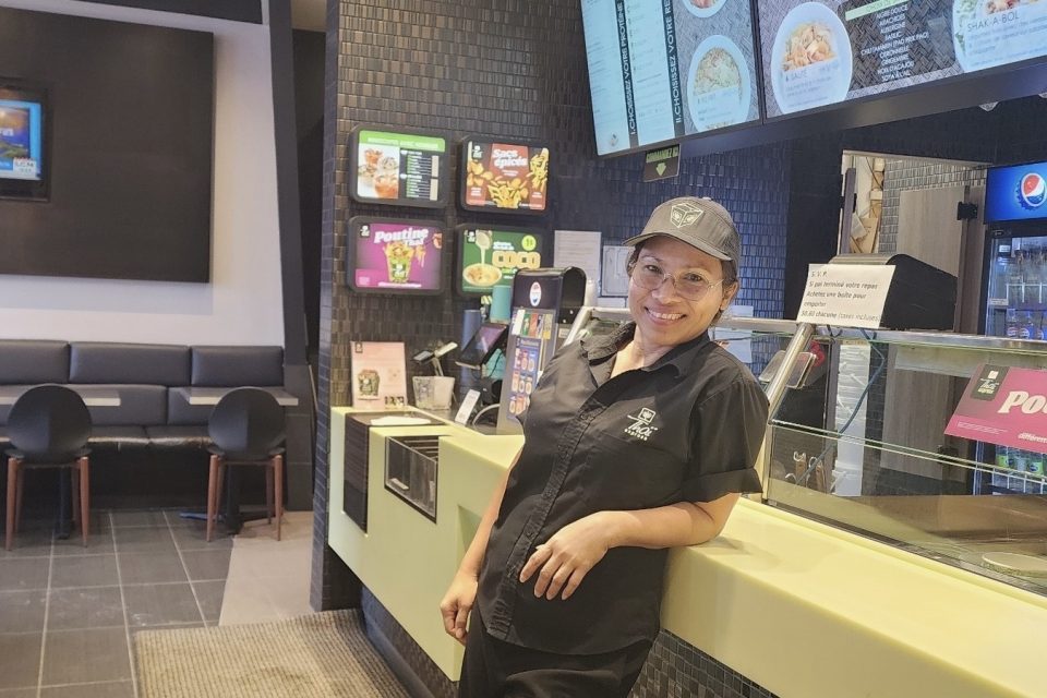 Propriétaire du Thaï Express Centre Lachenaie, souriante, près du comptoir des commandes